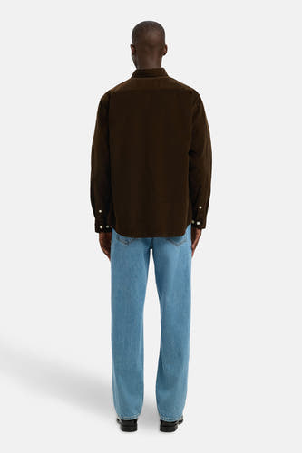 Chemise à manches longues brun fon de SELECTED, dé détails dé et etée avec des jeans bleus.