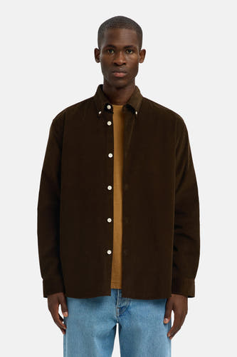 Chemise brune à manches longues de SELECTED, portée sur un T-shirt marron et des jeans bleu clair.