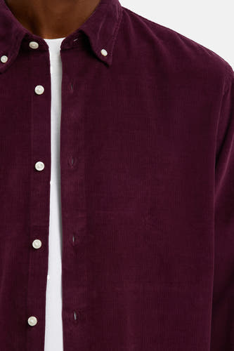 Chemise en corduroy bordeaux de SELECTED, avec des boutons en nacre et un T-shirt blanc dessous.