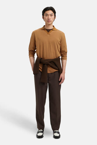 Polo beige de SELECTED, avec des manches longues et une ceinture brune nouée autour de la taille, associé à un pantalon brun et à des loafers.