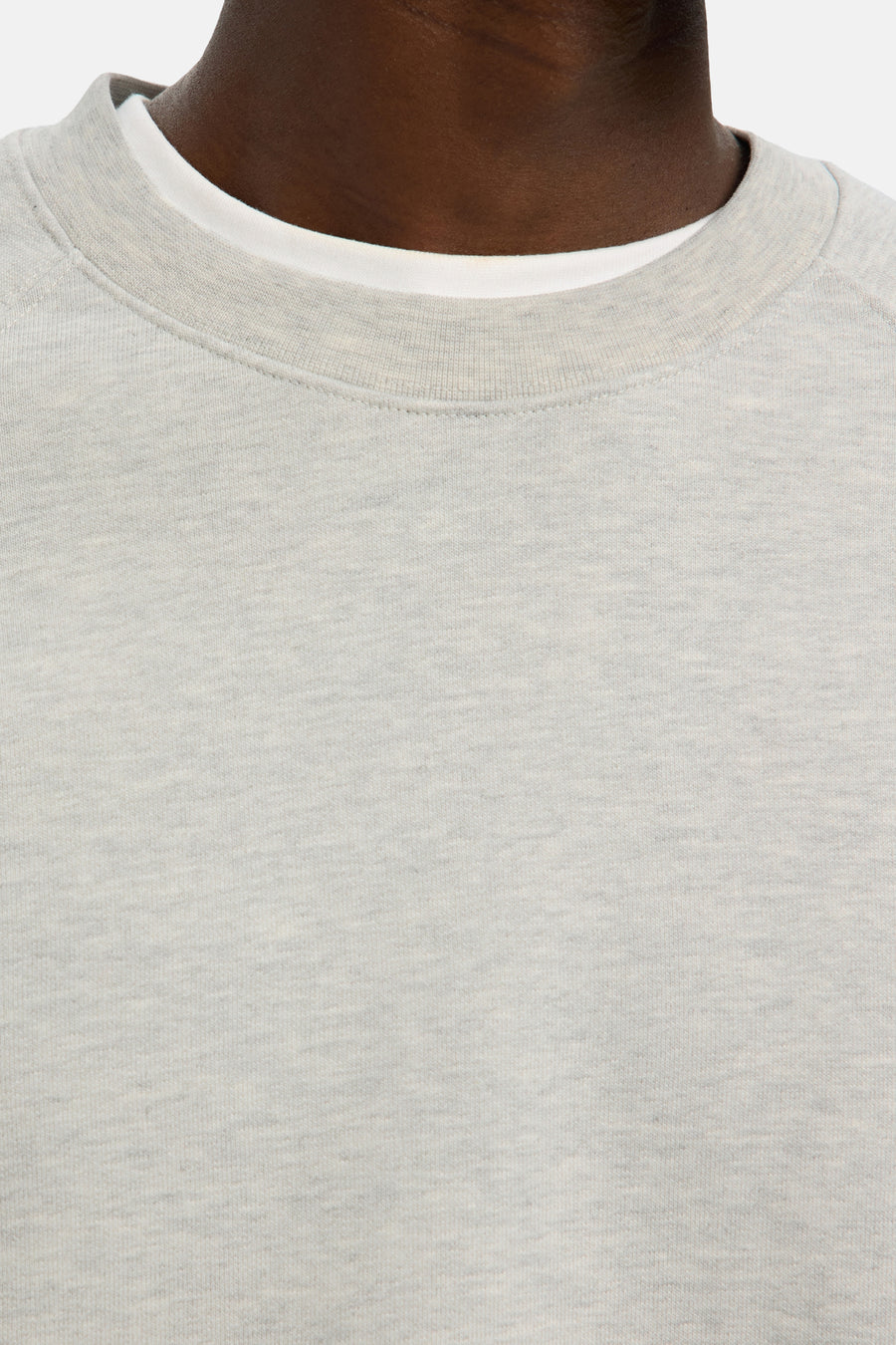 Grijze sweater met ronde hals, gedragen door een donker getinte man.