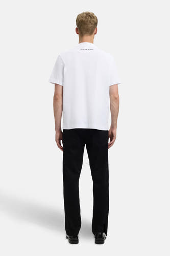 T-shirt blanc à manches courtes de SELECTED, vu de derrière, associé à un pantalon noir et des chaussures noires.