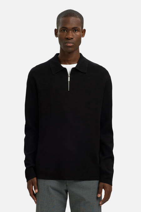 Pull-over noir avec col rond de SELECTED, doté d'une fermeture éclair argentée et d'un T-shirt blanc en dessous, porté avec un pantalon gris.
