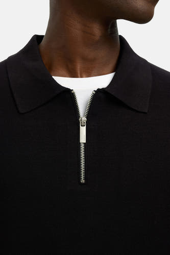 Pull noir avec col rond de SELECTED, avec une fermeture à glissière argentée et porté sur un T-shirt blanc.