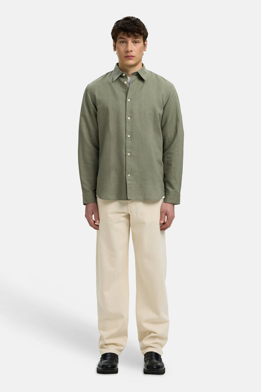 Chemise verte à manches longues de SELECTED, avec une texture légère, combinée avec un pantalon beige et des mocassins noirs.