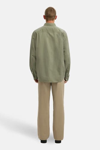 Chemise verte à manches longues de SELECTED, avec fermeture à boutons et portée avec un pantalon kaki, vue de dos.