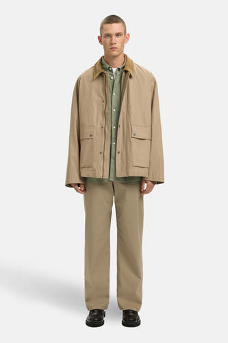 Chemise verte à manches longues de SELECTED, portée sous une veste et un pantalon kaki.