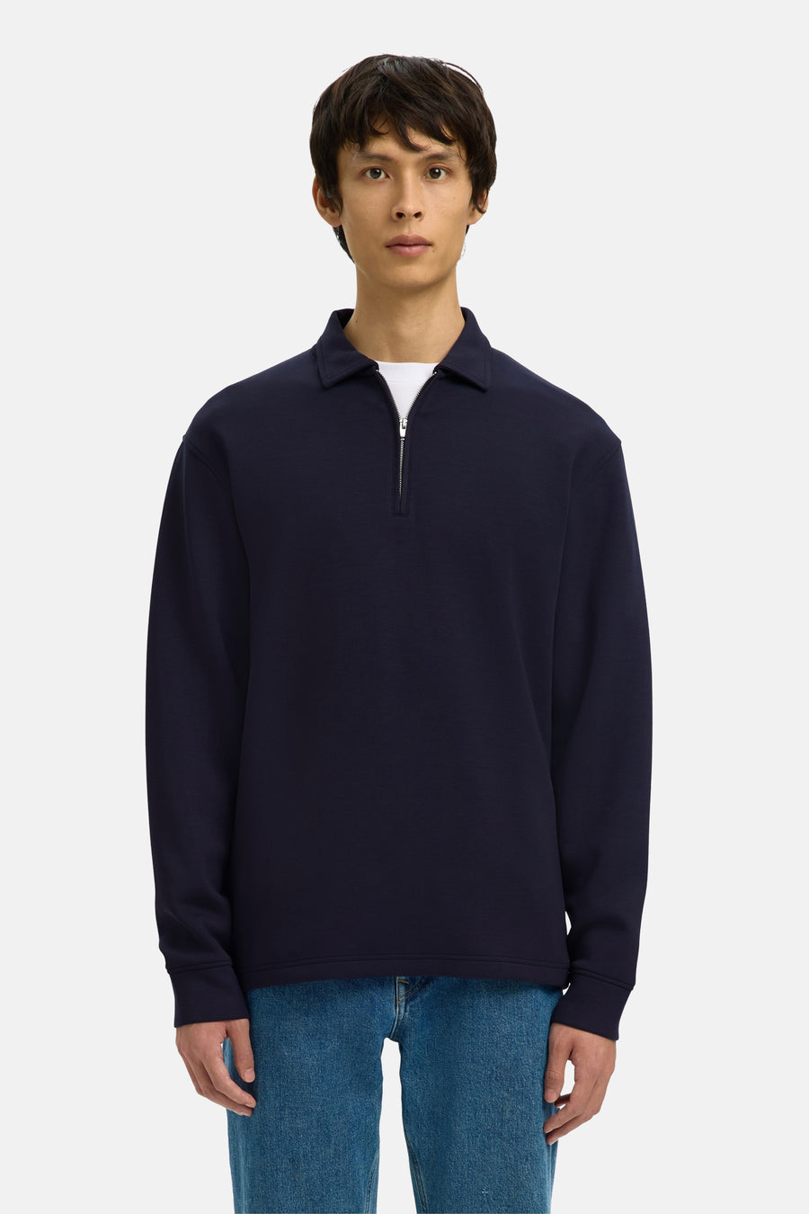 Pull bleu de SELECTED, porté avec un t-shirt blanc, un jean bleu et des chaussures noires.