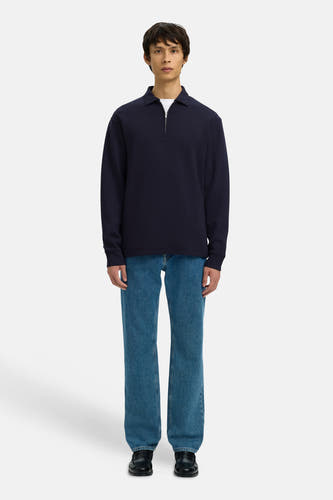 Blauwe sweater van SELECTED, gedragen met een wit T-shirt, blauwe jeans en zwarte schoenen.