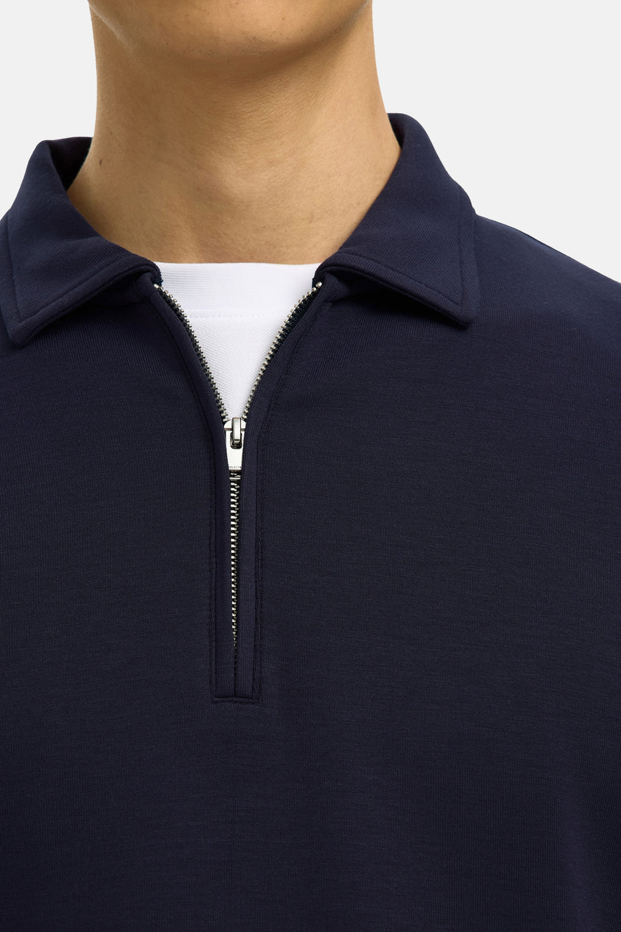 Pull bleu de SELECTED avec une courte fermeture éclair argentée et une sous-couche blanche.