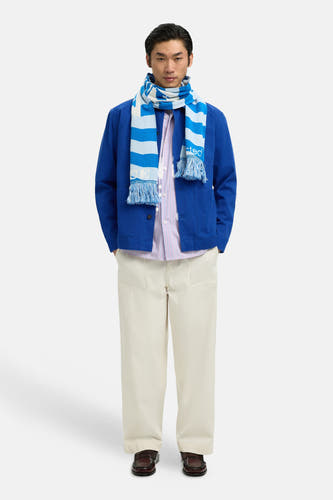 Manteau bleu de SELECTED, porté avec une écharpe rayée et un pantalon beige.