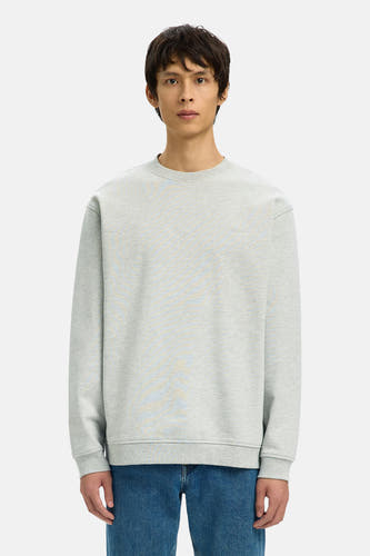 Pull gris à col rond de SELECTED, porté avec un jean bleu et des mocassins noirs.