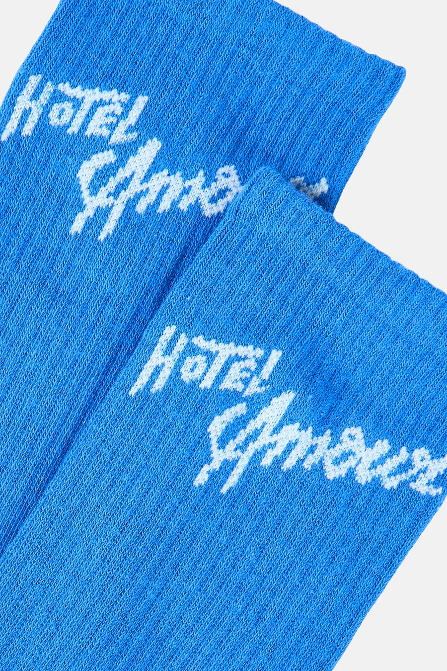 Blauwe sneaker sokken van SELECTED met wit "Hotel Amour" opschrift.
