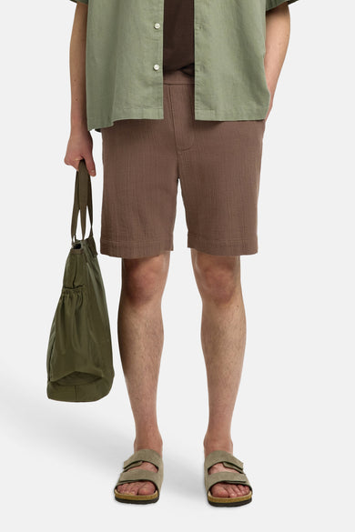 Bruine korte broek van textuurrijke stof van SELECTED, met zakken, gedragen met groen overhemd en sandalen, front view