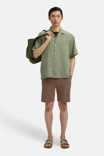 Bruine korte broek van SELECTED met fijne textuur, gedragen met groen overhemd en sandalen, front view