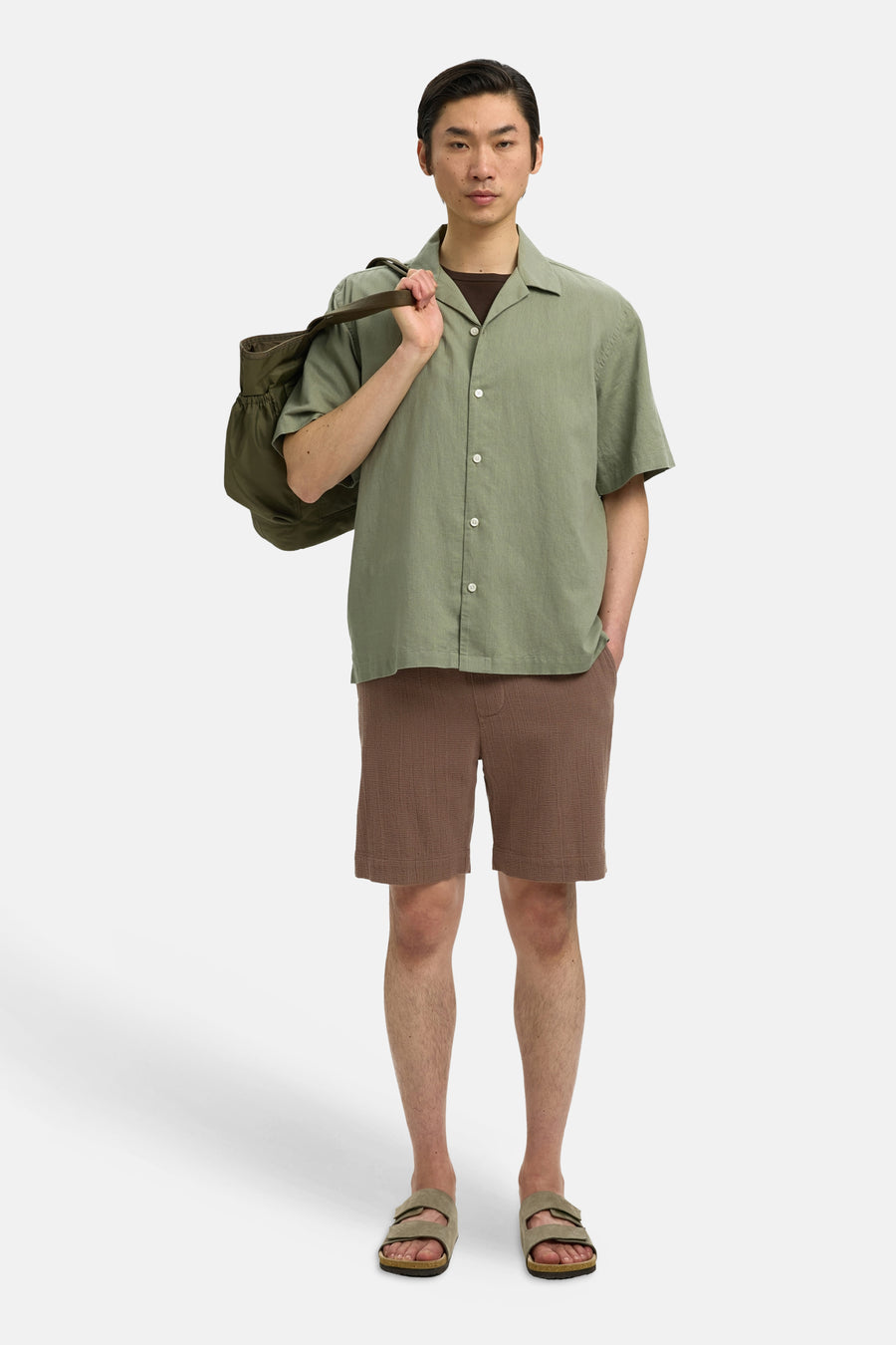 Bruine korte broek van SELECTED met fijne textuur, gedragen met groen overhemd en sandalen, front view