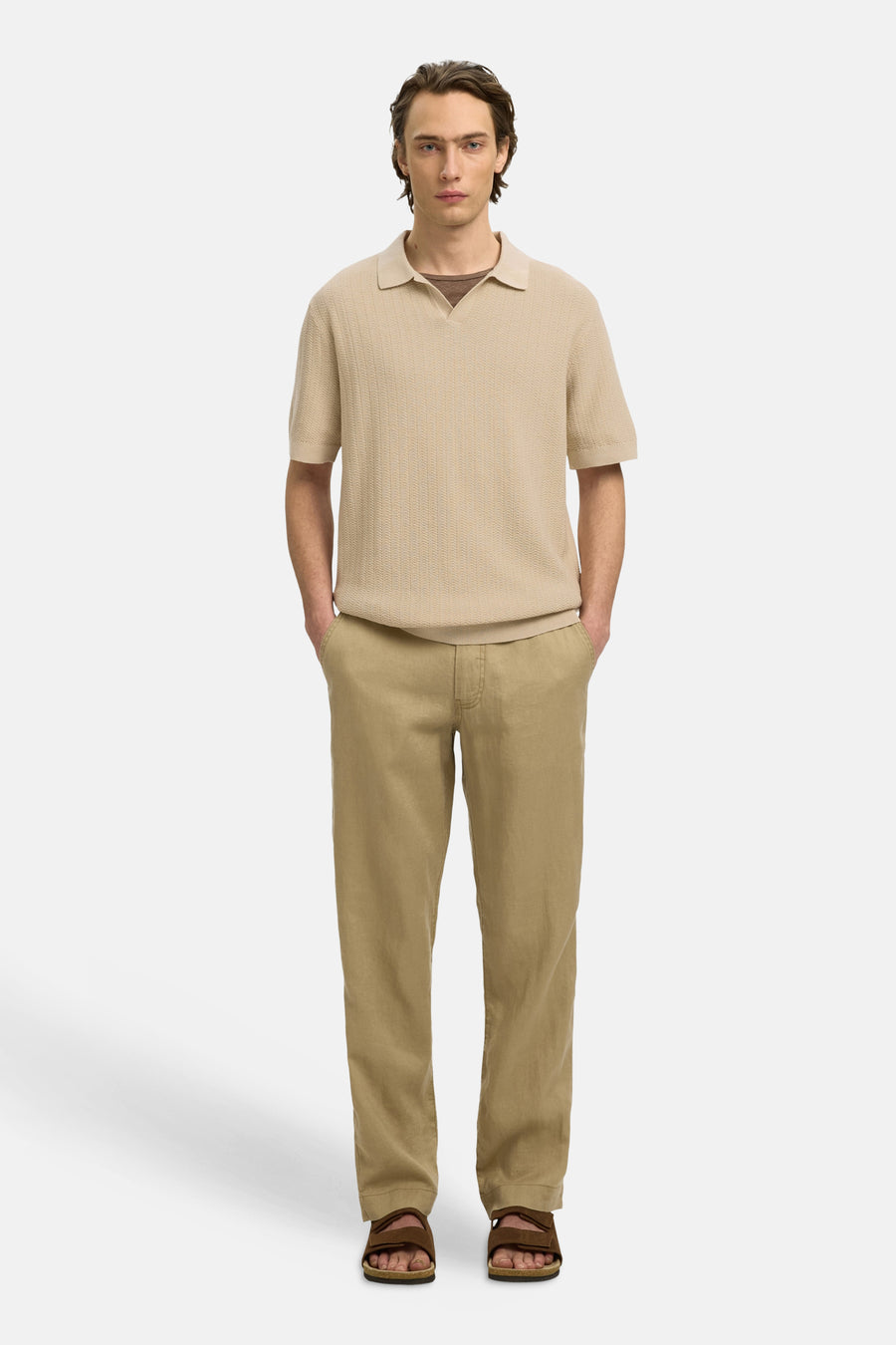 Polo beige de SELECTED, avec un tricot fin, des manches courtes et porté avec un pantalon kaki et des sandales marron.