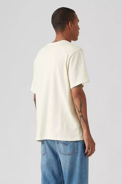 Ecru T‑shirt à manches courtes de Levi's®, avec des tatouages sur les bras, combiné avec un jean bleu.