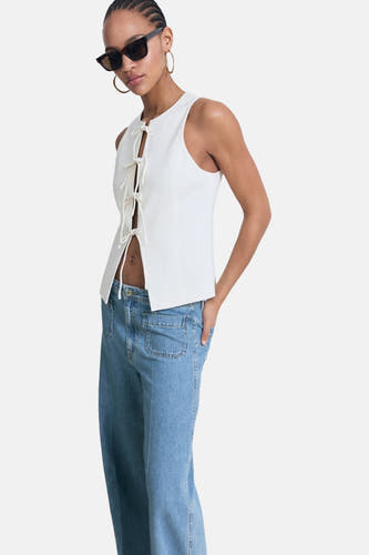 Jean bleu décontracté "EMMA" de MANGO, avec des poches brodées et porté avec un haut blanc.