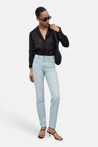Lichtblauwe mom jeans van MANGO, gecombineerd met zwarte blouse, tas over de schouder en zwarte hakken.
