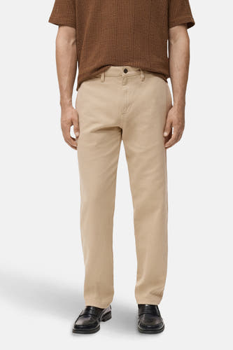 Jean beige de MANGO, avec un chemisier marron et des chaussures noires.