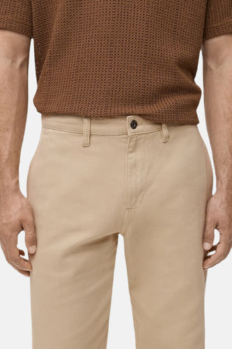 Jean beige de MANGO, avec une fermeture à bouton unique et des passants.