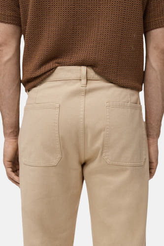 Pantalon beige de MANGO, avec des poches broiquées à l'arrière, vu de derrière.
