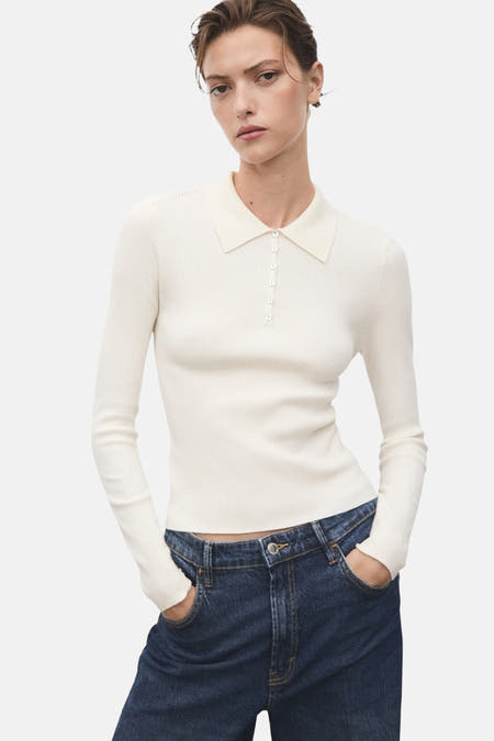 Pull beige à col rond de MANGO, côtelé et à longues manches, associé à un jean bleu marine.