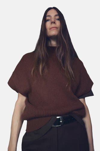T-shirt marron de MANGO, avec structure en côtes, associé à une jupe marron à plis verticaux, vu de dos.