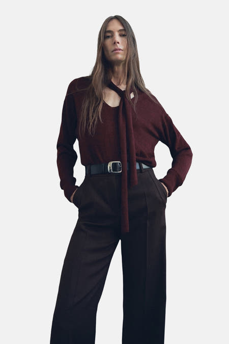 Veste Bordeaux avec col rond de MANGO, stylée avec un foulard décontracté et un pantalon foncé à haut taille avec ceinture.