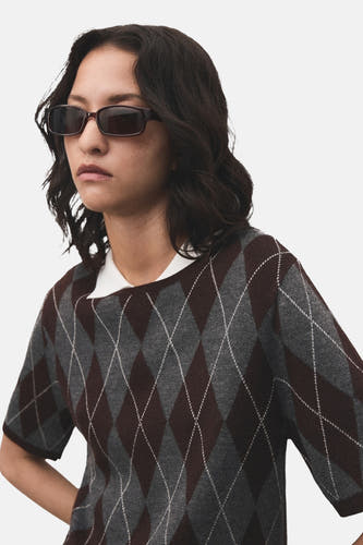Sweat-shirt multicolore à col rond de MANGO, avec un motif carreaux d'argyle et une blouse blanche en dessous.