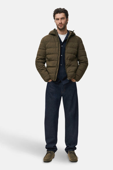 Manteau court en coton de MANGO avec capuche et fermeture éclair, porté sur un T-shirt blanc et un gilet bleu marine.