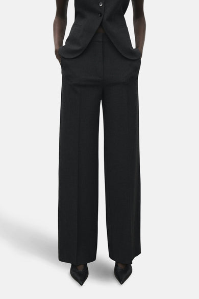 Pantalon gris de costume MANGO, avec des jambes larges et des poches à rabat, associé à un gilet coordonné.