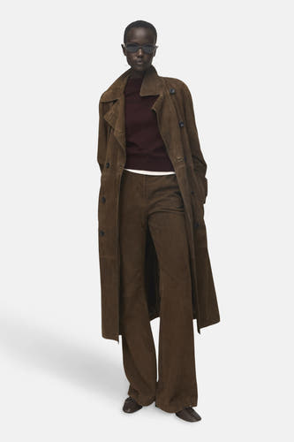 Veste Bordeaux avec col rond de MANGO, portée sous un manteau trench beige et une pantalon.
