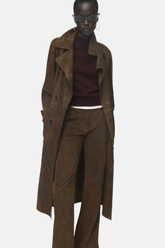 Sweat-shirt bordeaux avec col rond de MANGO, porté sous un trench-coat en cuir marron et une pantalon coordonné.