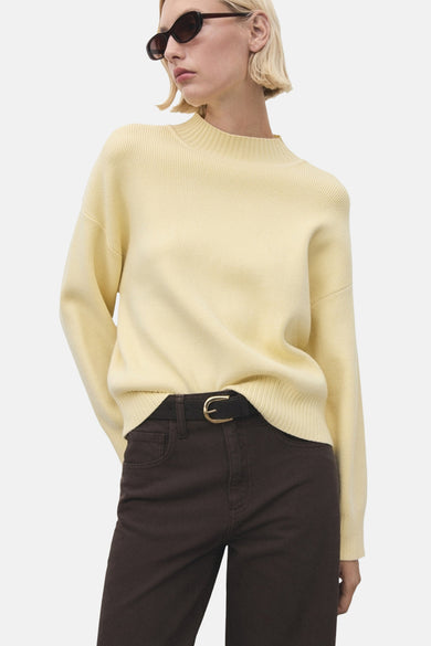 Sweat-shirt MANGO à col rond, dos, avec une texture tricotée, associé à un pantalon marron.
