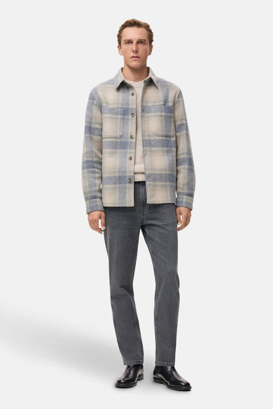 Multikleurige korte jas van MANGO, met een geruit patroon, gedragen met een crèmekleurige trui en grijze jeans.