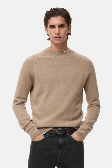 Sweat beige à col rond de MANGO, vu de derrière, associé à un jean foncé.