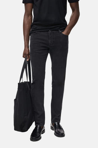 Jean slim fit gris anthracite de MANGO, avec une sacque noire et des chaussures en cuir noires.