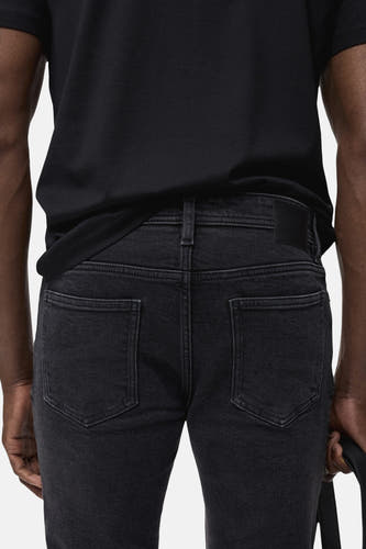 Jean slim fit couleur gris foncé de MANGO, dos, associé à un T-shirt noir.
