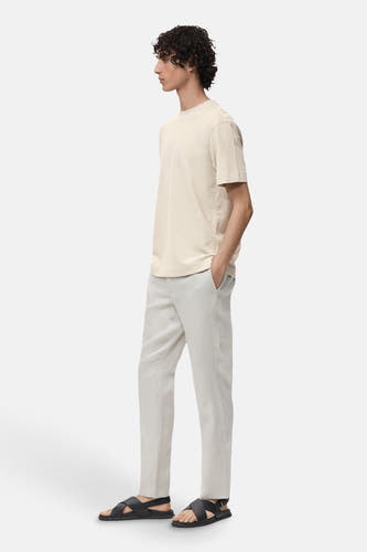 T-shirt gris à manches courtes de MANGO, porté avec un short léger et des sandales noires.