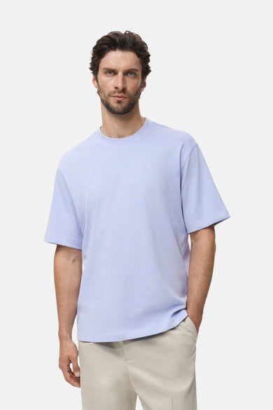 T-shirt bleu à manches courtes de MANGO, porté avec un pantalon beige.