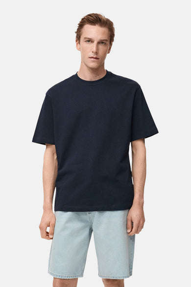T-shirt bleu marine à manches courtes de MANGO, porté avec un short bleu clair.