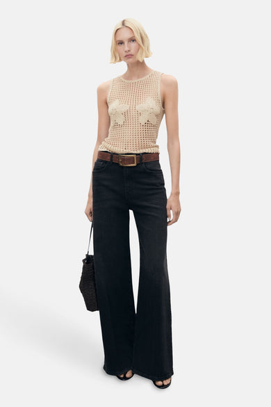Sous-vêtement beige de MANGO, avec des détails floraux, associé à une ceinture brune et à des jeans noirs larges.