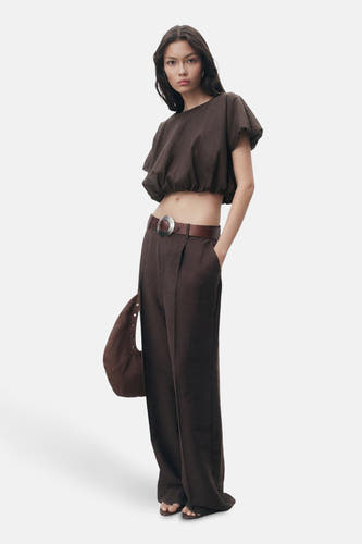 Blouse brune à manches courtes de MANGO, portée avec un pantalon brune à deses et et et une ce ce.