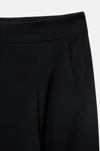 Pantalon de costume noir MANGO, avec une poche latérale et un tissu lisse et ajusté.