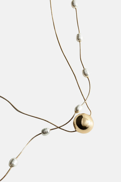 Collier court en or de MANGO, avec des perles et une grande boule d'or.