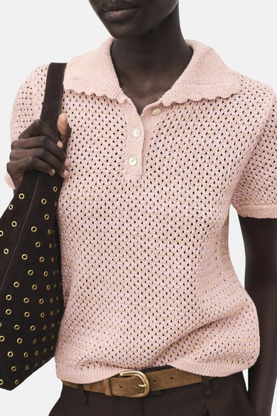 Polo rose à manches courtes de MANGO, avec une texture crochetée et porté avec un sac brun.