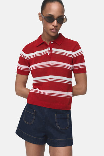 Sweat-shirt multicolore à col rond de MANGO, avec un motif rayé et des manches courtes, porté avec un short en denim.