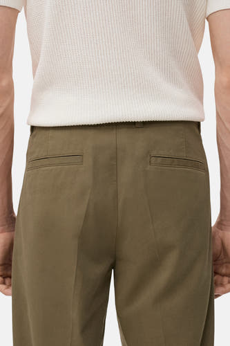 Pantalon khaki de MANGO, avec des poches passepoilées à l'arrière et une coupe ajustée.